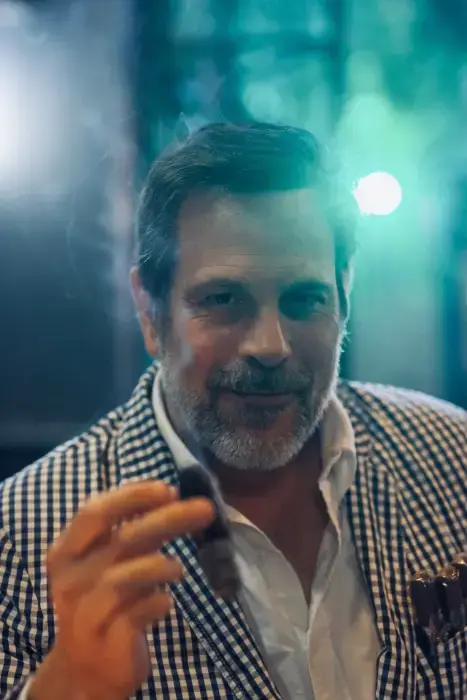 Iván Gancedo holding a cigar at an evening event