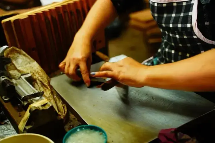 A torcedor hand-rolling a cigar at a workbench
